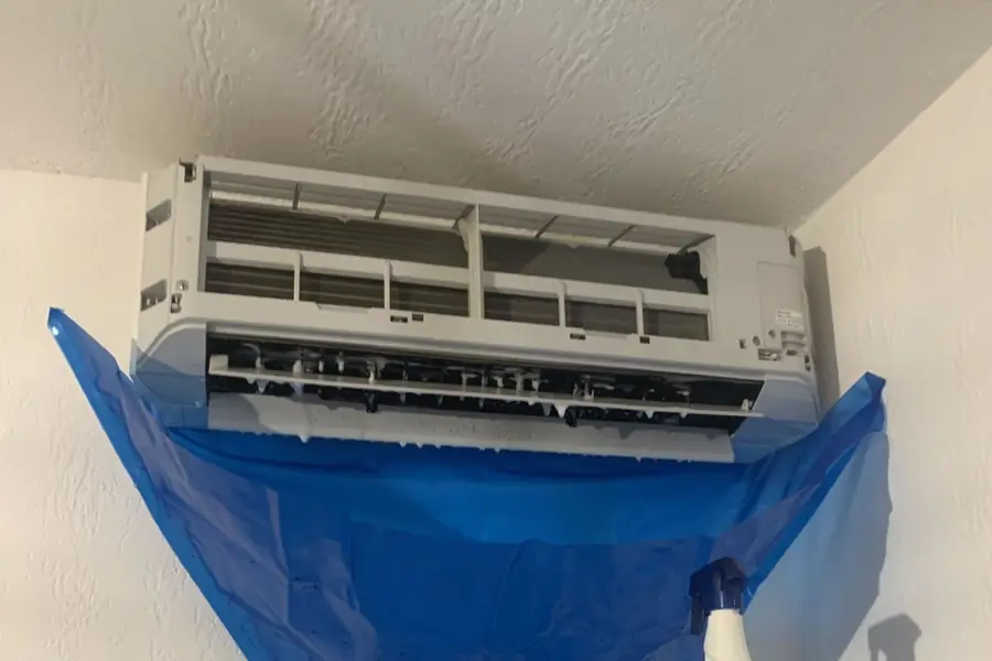 Nettoyage de l’unité intérieure d’une climatisation avec une housse de récupération