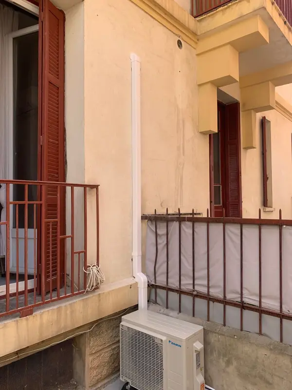 Unité extérieure Daikin posée sur une loggia à Ajaccio, liaisons sous goulotte